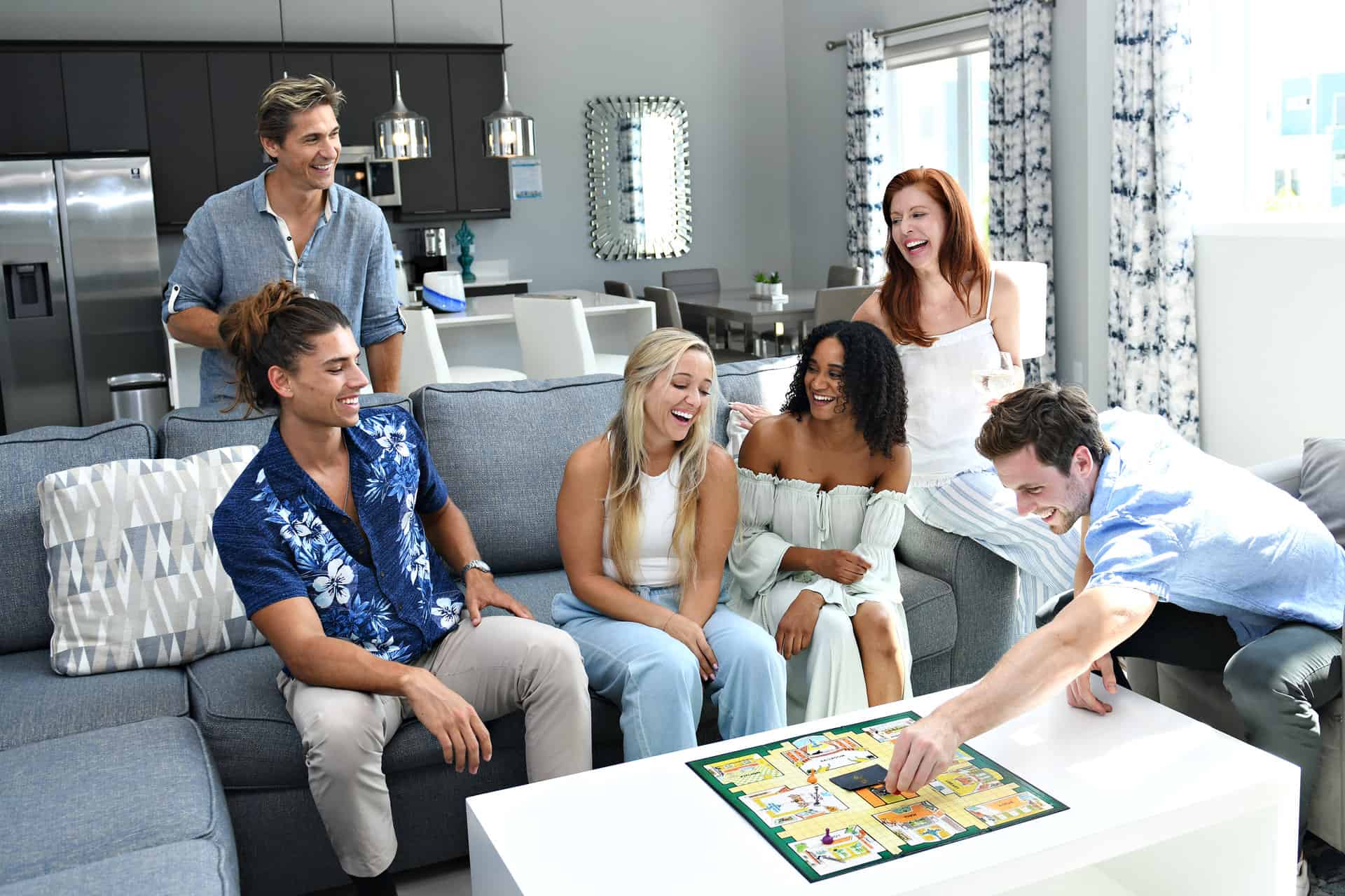 Group laughing while playing a board game in a Rentyl at Reunion home