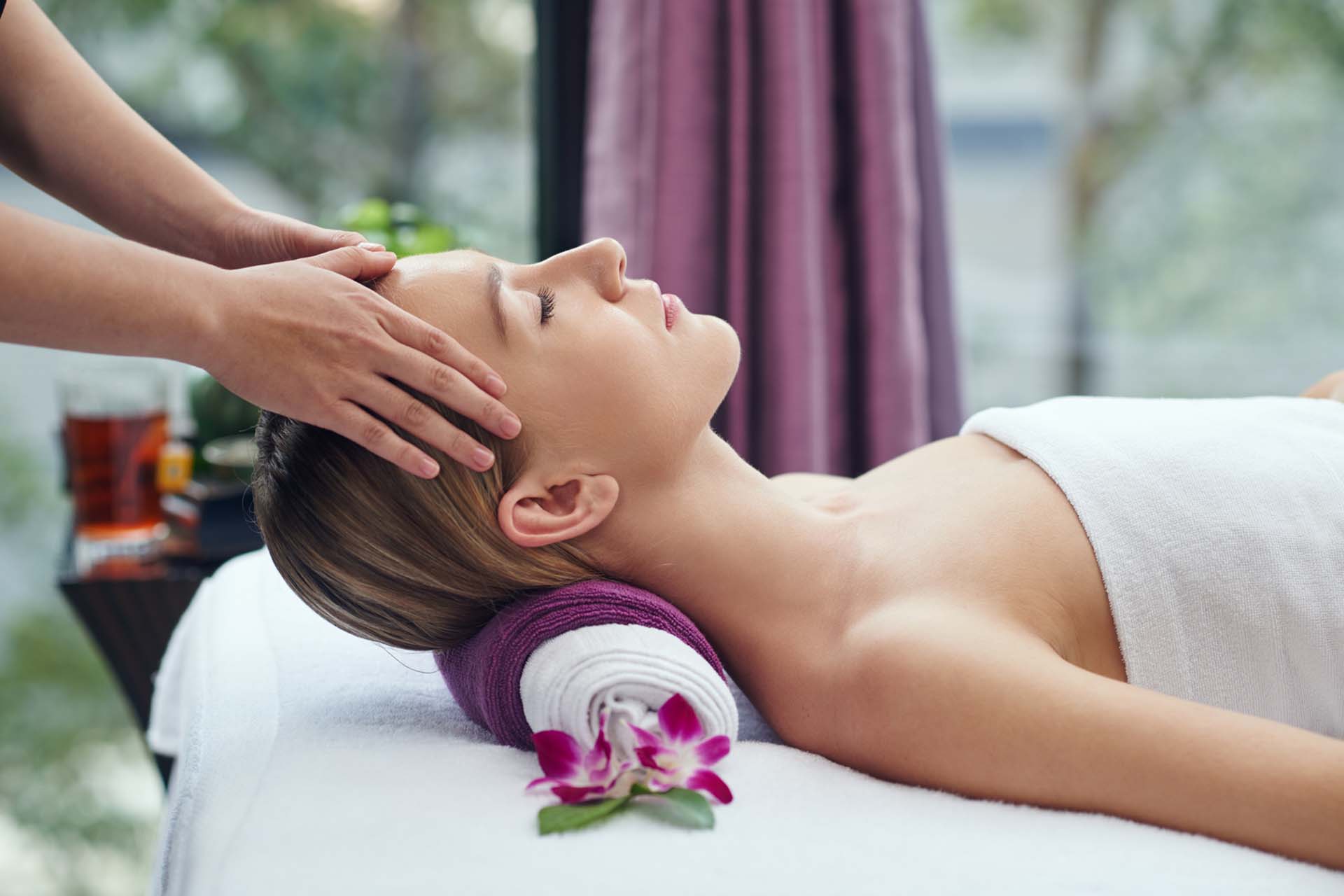 Woman lying on a massage table receiving a spa treatment