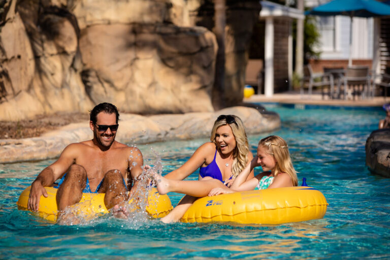 Happy family splashing in tubes along the lazy river at the Rentyl at Reunion Water Park